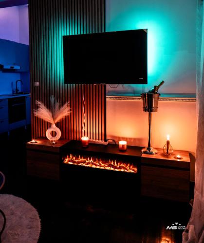 a living room with a fireplace with a tv above it at MB Loveroom Spa in Le Blanc-Mesnil