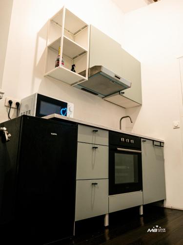 a kitchen with a stove and a microwave at MB Loveroom Spa in Le Blanc-Mesnil