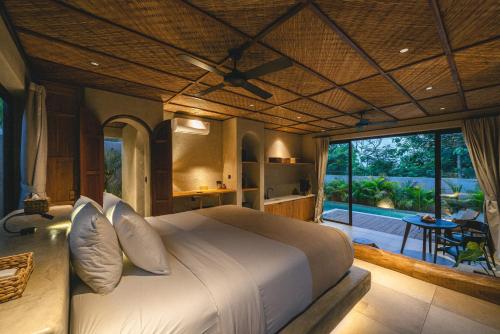 a bedroom with a large bed and a large window at SIVANA, Hotel Boutique with ocean or garden views - Adults only in Uluwatu