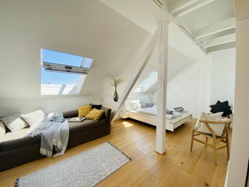 a living room with a couch and a window at Ferienwohnung Circus Loft in der Villa Circus Putbus in Putbus