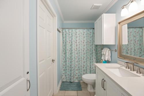 a bathroom with a toilet and a sink and a mirror at Grand Caribbean West Unit 103W By Pkrm in Pensacola