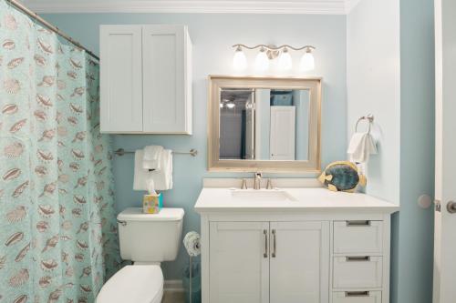 a bathroom with a toilet and a sink and a mirror at Grand Caribbean West Unit 103W By Pkrm in Pensacola