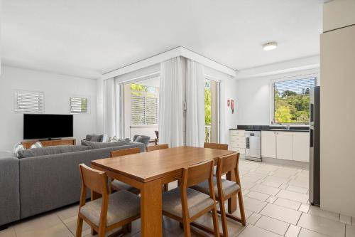 a living room with a table and a couch at Hastings Suites by Stay Noosa in Noosa Heads