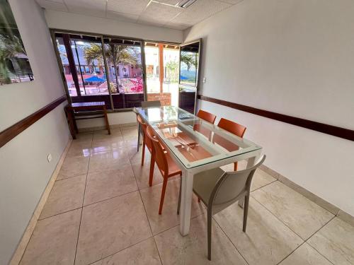 a dining room with a glass table and chairs at Hotel Los Viñedos in Lemos