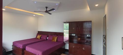 a bedroom with two beds and a ceiling fan at Glasshouse Retreat by The Jungle stay groups in Vālpārai