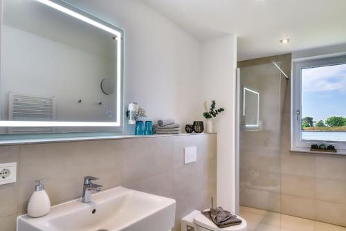 a bathroom with a sink and a mirror at Ferienwohnung Haubentaucher 25 im Wreecher Idyll Rügen by ruyastay in Putbus