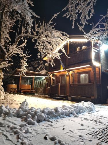 a pile of snow in front of a log cabin at Family Plai in Yaremche