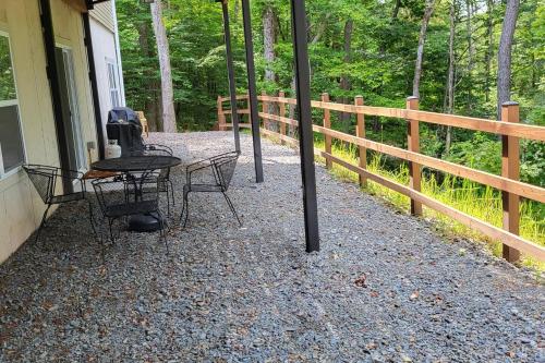 a table and chairs on the porch of a house at Serenity On The Lehigh River in Thornhurst