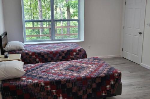 a bedroom with two beds and a window at Serenity On The Lehigh River in Thornhurst