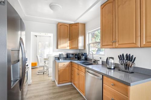 a kitchen with wooden cabinets and stainless steel appliances at Modern Oasis with Pool & Jacuzzi near Universal Studios in Los Angeles