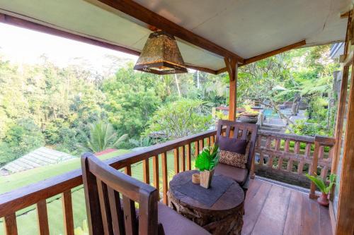 a porch with a table and chairs on a balcony at Doni House & Villas in Ubud