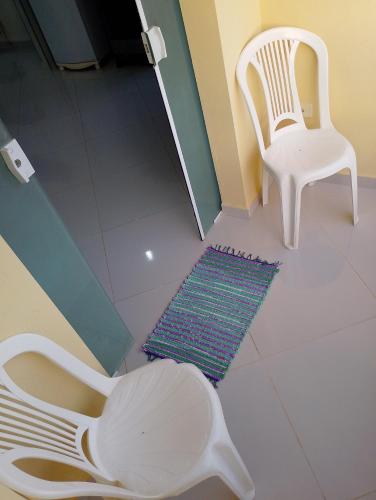 a white chair and a rug on a white floor at Cobertura com área privativa,a melhor Vista. in Cabo de Santo Agostinho