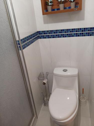 a white bathroom with a toilet and a shower at Destino Marino Apartamento con vista al mar Tucacas in Tucacas