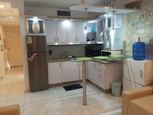 a kitchen with a table and a refrigerator at Destino Marino Apartamento con vista al mar Tucacas in Tucacas
