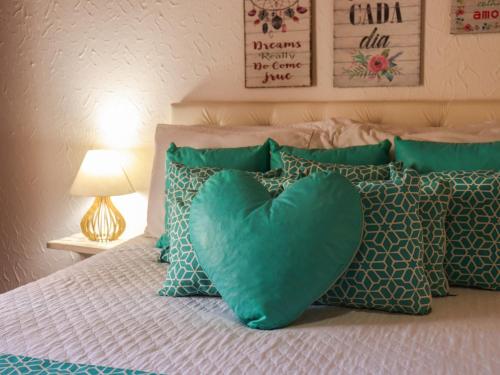 a heart pillow sitting on a bed with pillows at Pousada Pura vida in Itacaré