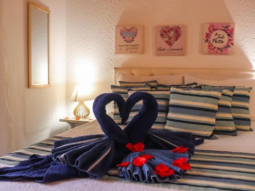 a bed with towels in the shape of a heart at Pousada Pura vida in Itacaré