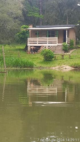 a house on the shore of a body of water at Cabana de pesca e lazer Represa Usina Mafra sc in Mafra