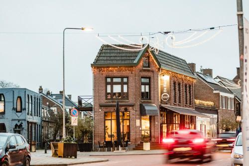 a red truck driving past a brick building on a street at Reffel Suites in Gennep
