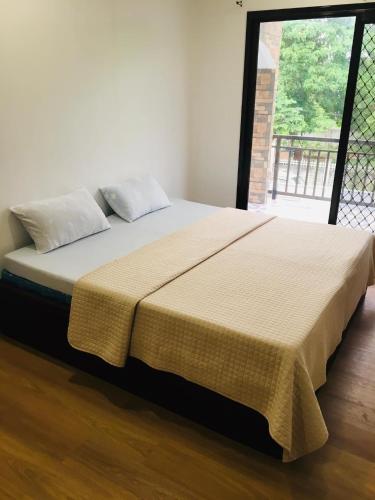 a bed with a yellow blanket on top of it at Mommy Mia Bed and Breakfast in Dasag