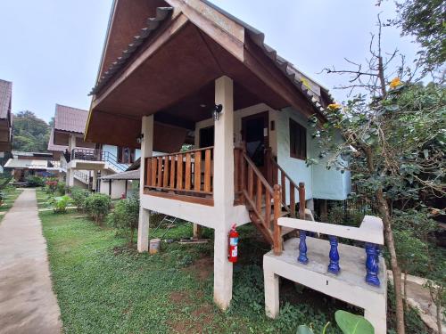 a small house with a porch and a staircase to it at Sleep Pai Bed & Breakfast in Pai