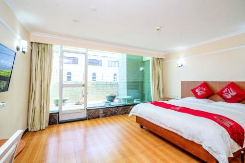 a bedroom with a large bed and a large window at LN Whitehouse Hotel in Guangzhou