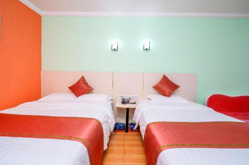 a room with two beds and a table in it at LN Whitehouse Hotel in Guangzhou