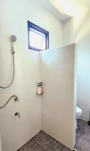 a bathroom with a shower with a toilet and a window at Sisters Real Escapes - Entire Villa in Mae Sot