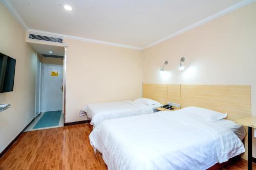 a hotel room with two beds and a television at LN Whitehouse Hotel in Guangzhou