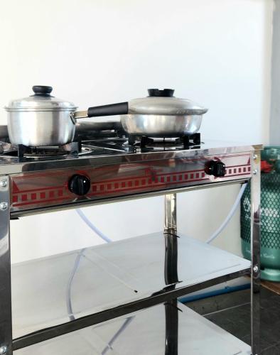 two pots sitting on top of a stove at Sisters Real Escapes - Entire Villa in Mae Sot