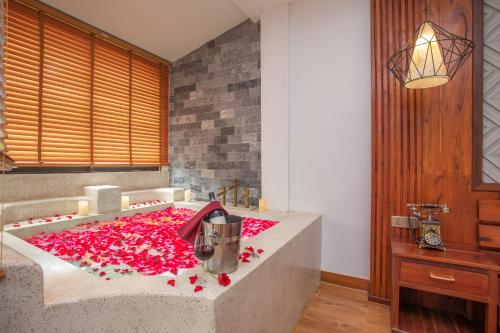 a bathroom with a tub filled with red flowers at Cambana La Rivière Hotel in Battambang