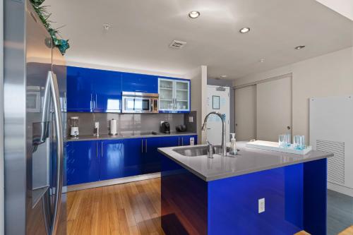 una cucina con armadi blu e frigorifero in acciaio inossidabile di 2BR W Resort, Birds eye view of it all, Professionally Designed a Fort Lauderdale