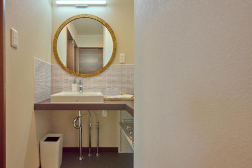 a bathroom with a sink and a mirror at Go Home 豪 in Furano