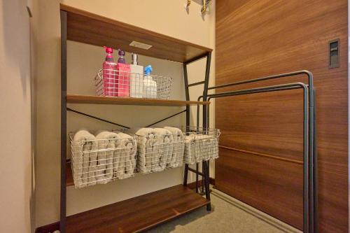 a walk in closet with baskets and a door at Go Home 豪 in Furano