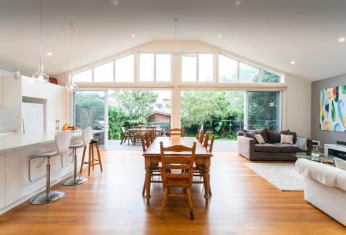 a kitchen and living room with a table and chairs at Beach House Close to Manly in Sydney