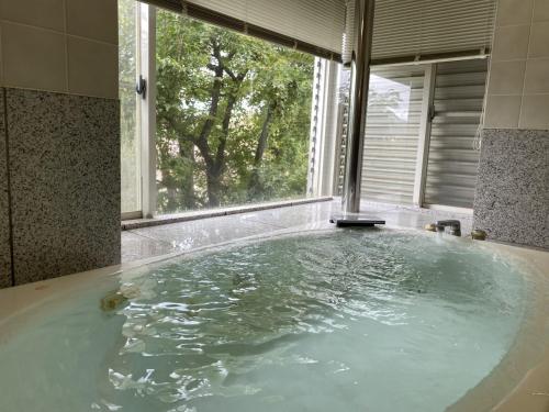 a large bath tub with a large window in a bathroom at Atami Venus in Atami