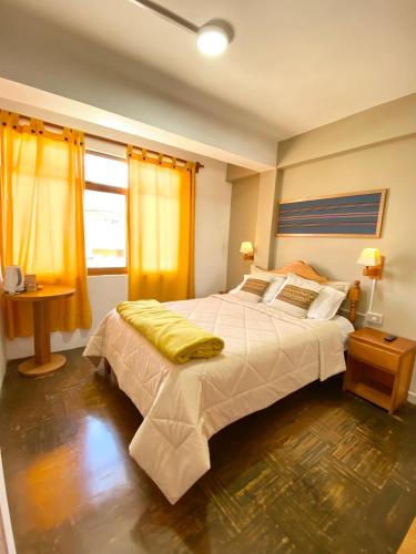 a bedroom with a large bed with yellow curtains at El Jacal Classic in Huaraz