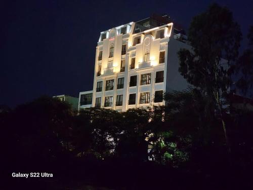 a tall white building with its lights on at night at SUN HOTEL & APARTMENT in Bắc Ninh
