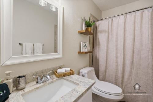 a bathroom with a sink and a toilet and a mirror at AT&T, Globe Life, Six Flags - Updated Comfy Home in Grand Prairie