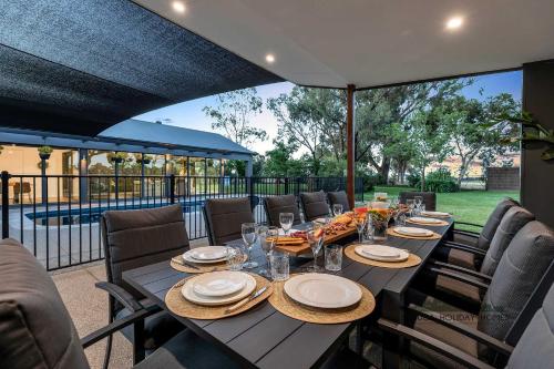 una mesa con platos y vasos en el patio en Palamcotta Lodge, en Moama