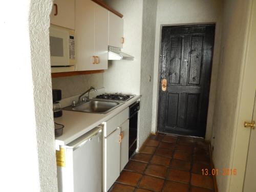 a kitchen with a sink and a black door at Real del Mar Golf Resort in Tijuana