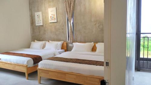 two beds in a room with a window at Silvan Garden Cameron Highlands in Tanah Rata