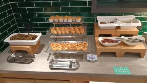 a bakery counter with various types of pastries on display at Qiuguo Hotel Chongqing Guanyin Bridge Branch in Chongqing