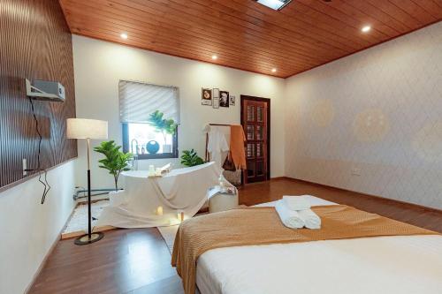 a bedroom with a large bed and a bath tub at Biệt Thự Đà Lạt Nghỉ Dưỡng Gia Đình in Trai Mat