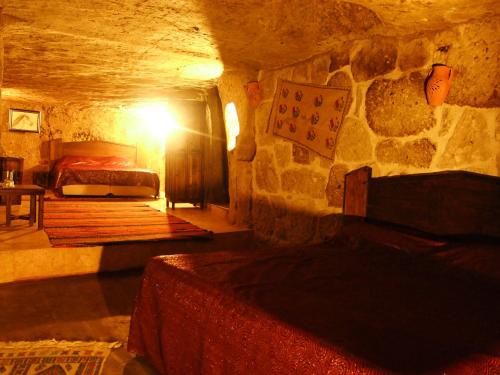 a bedroom with a bed in a stone cave at Kapadokya Ihlara Konaklari & Caves in Guzelyurt