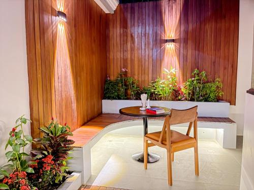 a small table and chair in a room with plants at Cambana La Rivière Hotel in Battambang