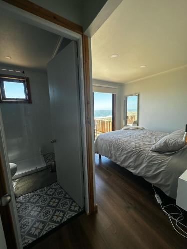 a bedroom with a bed and a view of the ocean at Casa Olas, Refugio Costero in Curanipe