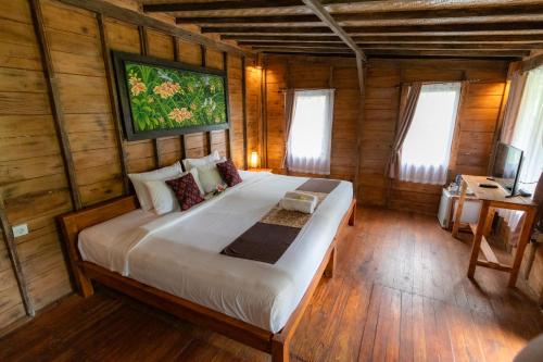 a bedroom with a large bed in a wooden room at Doni House & Villas in Ubud