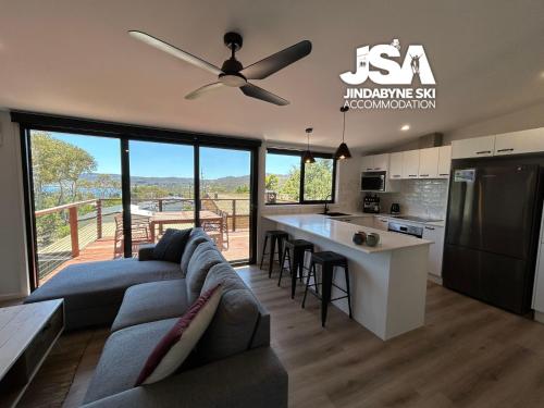 a living room with a couch and a ceiling fan at Casa Della Vita in Jindabyne