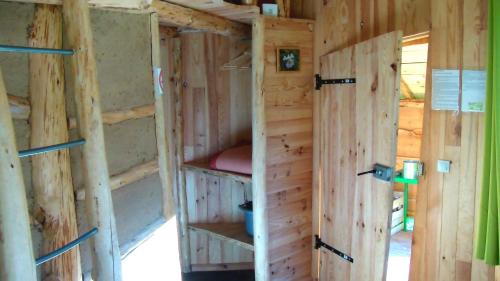 an inside of a wooden house with two shelves at La Clairière du Verbamont in Claudon