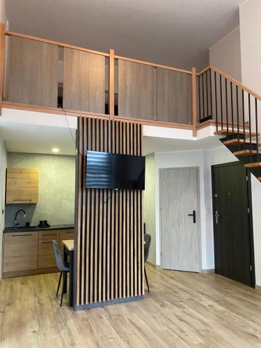 a living room with a staircase and a kitchen at Willa Platanowe Wzgórze in Wojcieszyce